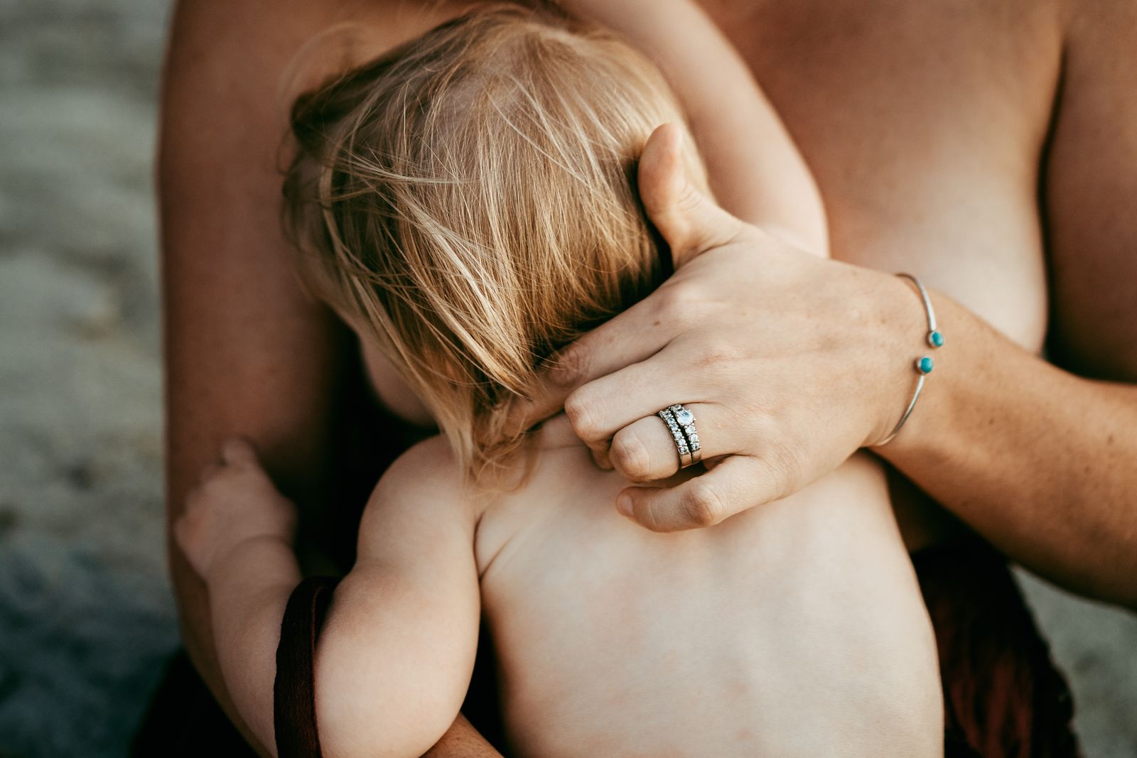 Baby resting skin to skin on mum's chest, her hand on his back