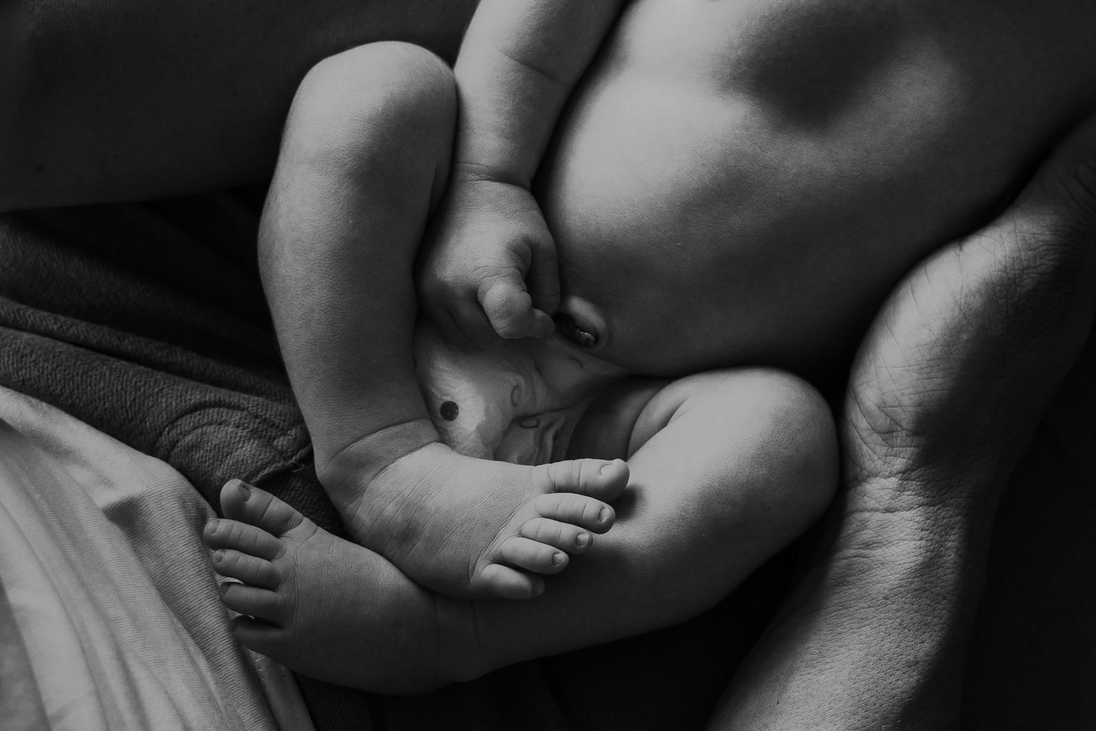 Black and white detail of a baby's feet held close