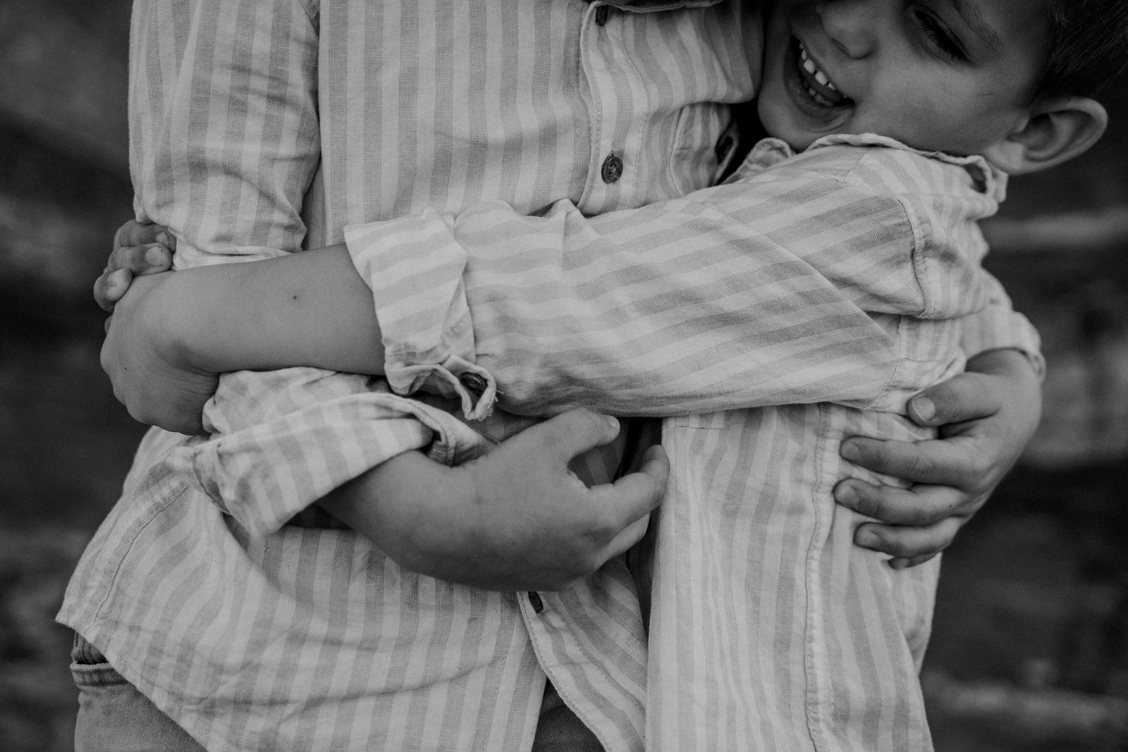 Black and white close-up of two brothers wrapped in a hug