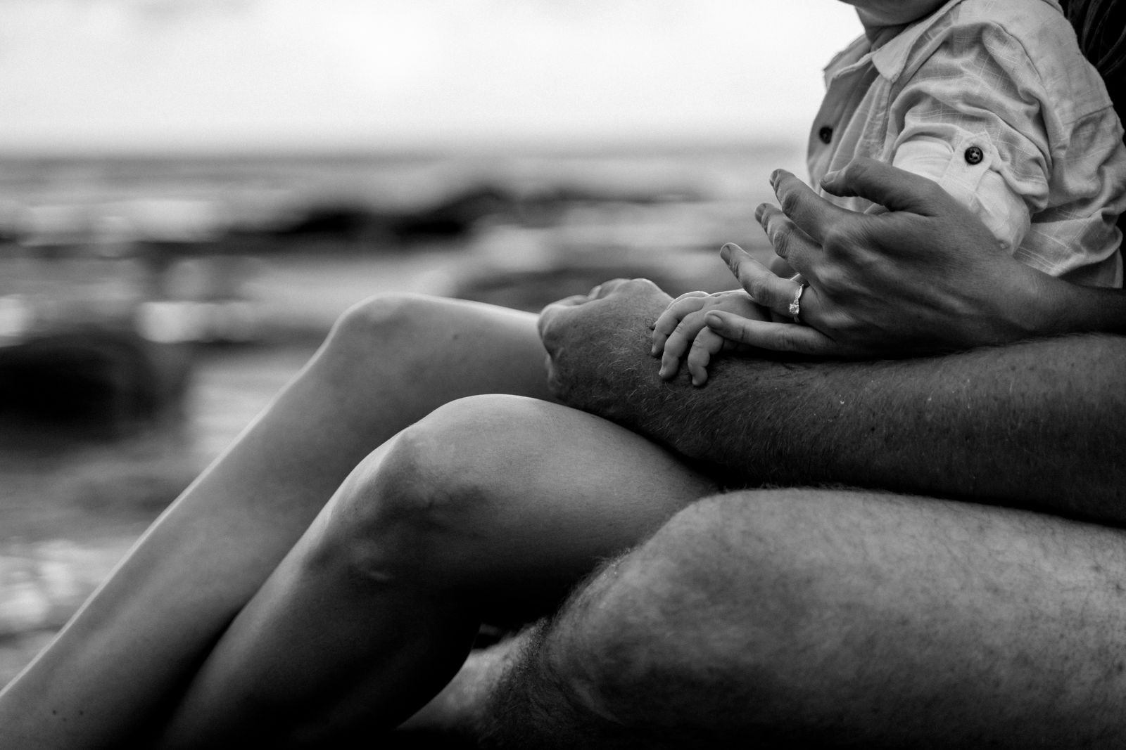 Black and white photo of a mum-to-be resting by the sea