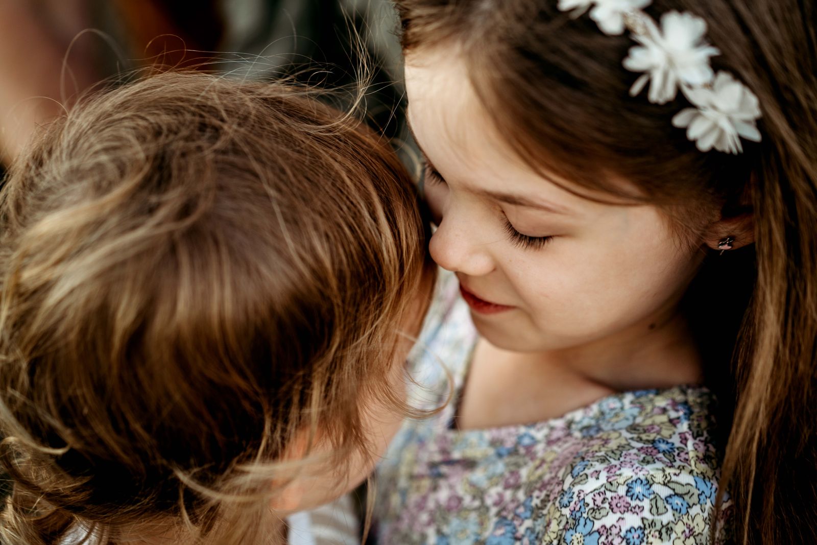 Little girl in a flower crown cuddling her sibling