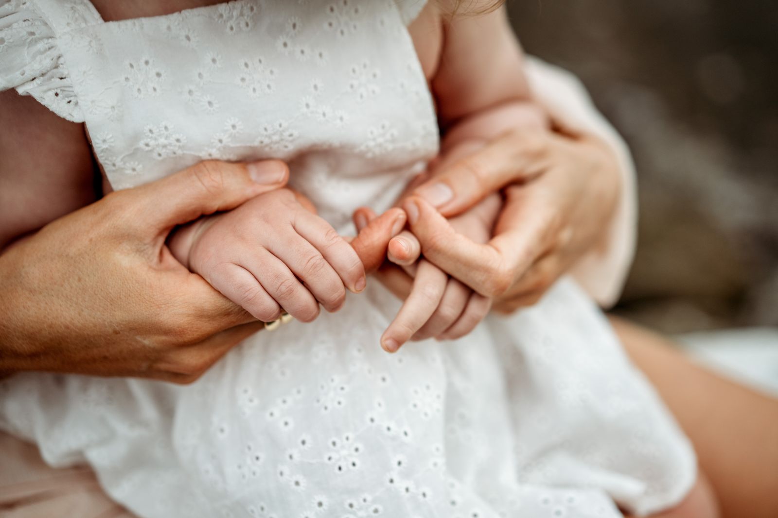 Close-up of hands holding a baby's tiny feet