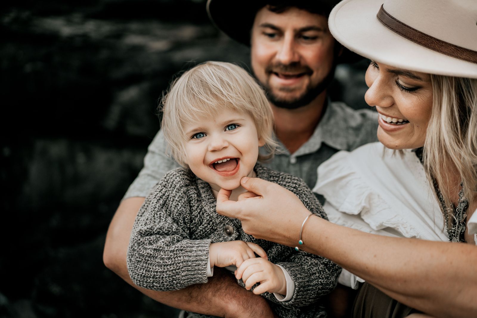 Mum and dad laughing with their toddler between them